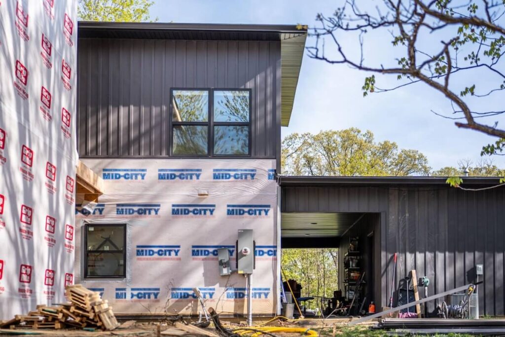 A home in the process of having TruLog steel board and batten siding installed