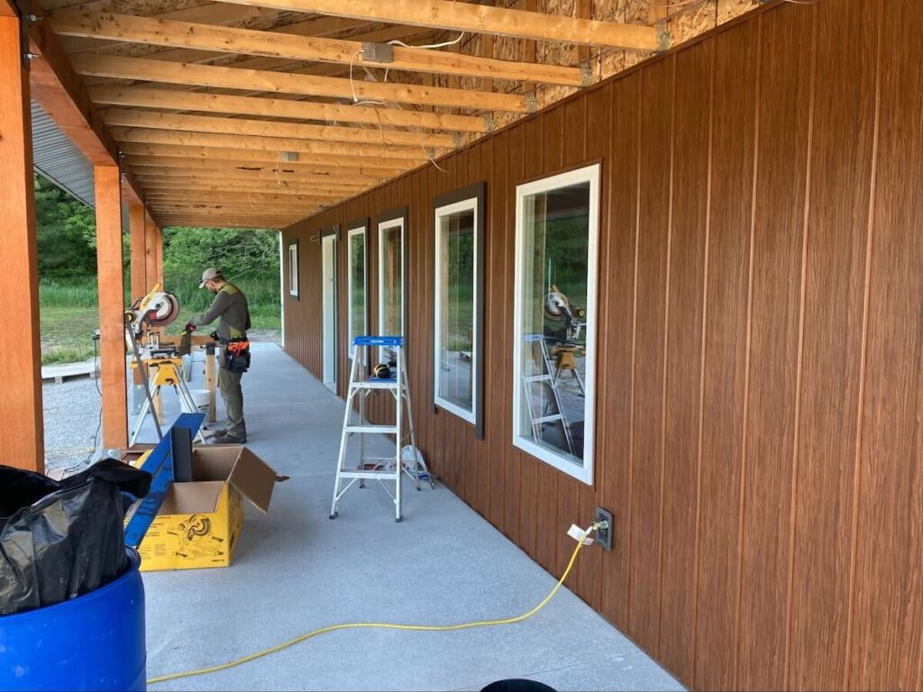 A contractor uses a circular saw while installing TruLog steel board and batten siding