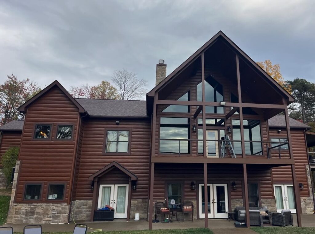 A house with a mix of two home siding options: TruLog steel log siding and a stone base
