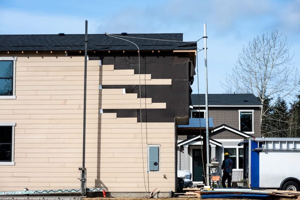 New wood lap siding being installed on the side of a home