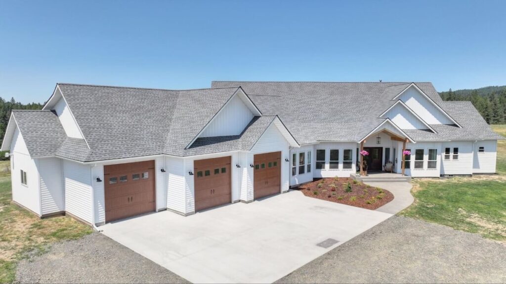 A sprawling home with a mix of TruLog steel lap and board and batten siding in Matte White along with wood accents