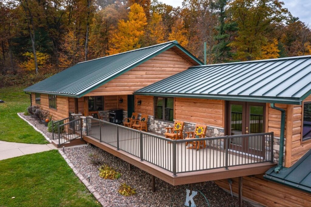 A modern log cabin with a standing seam metal roof and TruLog steel log siding in Hickory